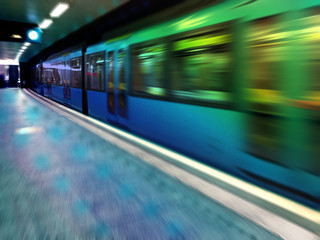 The train travels at high speed along the platform, artistically blurred image