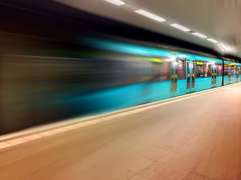 The train travels at high speed along the platform, artistically blurred image