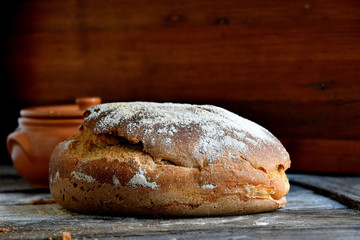 Homemade rustic bread on a wooden background.