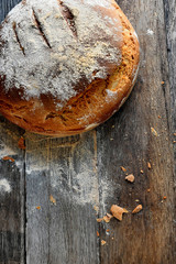 Homemade rustic bread on a wooden background.