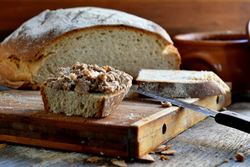 Homemade rustic bread and chicken pate on a wooden background.