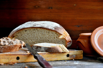 Homemade rustic bread and chicken pate on a wooden background.
