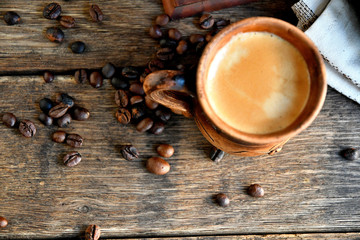 Top view of a cup of coffee, on a wooden background.