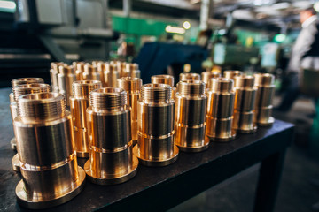 New brass threaded bushings on table in factory