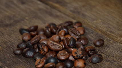 Roasted coffee grains on wooden boards.
