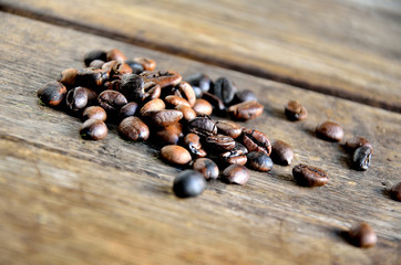 Roasted coffee grains on wooden boards.