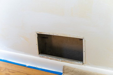 HVAC vent duct with the gate removed during home renovations and painting. Painters tape and tarp in photo