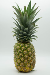 Fototapeta premium single standing pineapple with a large stem on an isolated white background