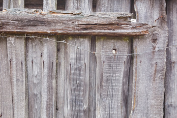 Texture of old gray fence and barbed wire