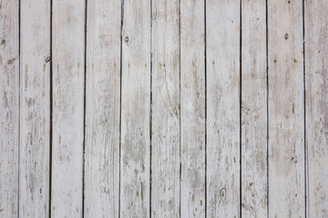 The texture of the old shabby fence of painted white paint boards