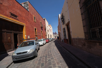 Cars line a cobblestone backstreet in Queretaro Mexico