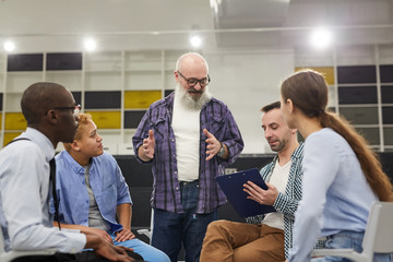 Portrait of smiling senior man giving speech during therapy session in support group, copy space