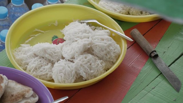 Tasty local menu for morning breakfast or snacks called 'Putu Mayang' in the traditional floating market of Banjarmasin, South Kalimantan / Borneo, Indonesia. 4K Ultra HD.