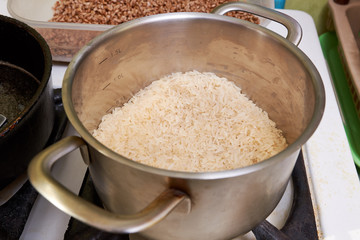 boiled rice in a stainless steel pan on a gas stove. cooking rice dishes. homemade vegetarian food