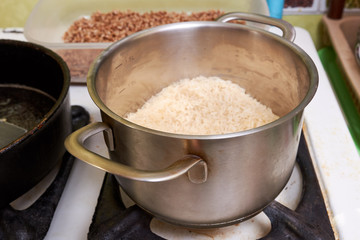 boiled rice in a stainless steel pan on a gas stove. cooking rice dishes. homemade healthy vegetarian food. Asian cuisine
