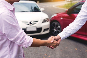 Customer shake hand with auto insurance agents examining car crash owner after agreeing find a...