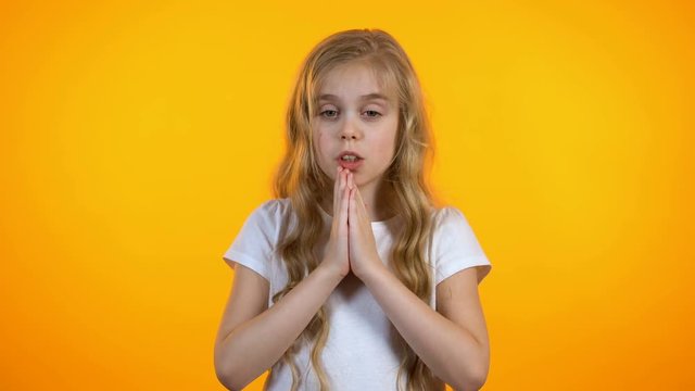 Cute schoolgirl praying, asking for dearest wish come true, anxious before exam