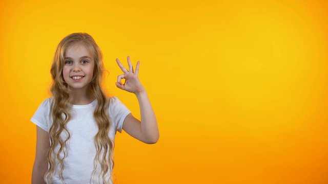 Adorable teen girl showing ok sign and winking, recommending service, template