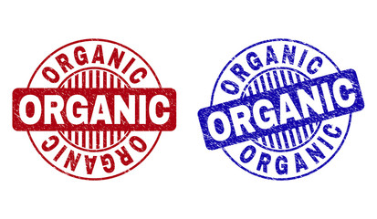 Grunge ORGANIC round stamp seals isolated on a white background. Round seals with grunge texture in red and blue colors. Vector rubber watermark of ORGANIC title inside circle form with stripes.