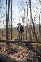 one young man, finding balance while standing on wood log.