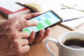 Message app on smartphone screen.Closeup of male hands touching smartphone screen at table.