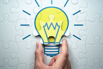 Concept image of solution.  Finding answer to problem.Solving lightbulb jigsaw puzzle.