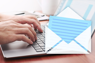 Email concept. Replying to received email. Using laptop at wood table.