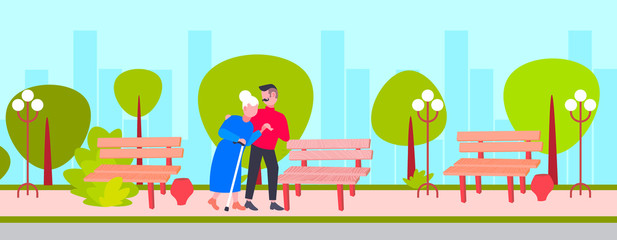 Fototapeta premium young man helping elderly gray haired grandmother guy strolling with old lady city urban park care support concept cartoon characters full length flat cityscape background