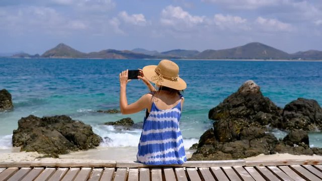 Young woman traveler take a picture at the tropical beach, Summer vacation and travel concept