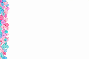 Obraz premium Pink and blue Sewing buttons on white background. Top view. Free space. Border