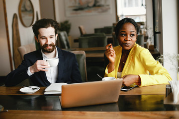 Handsome man in a black suit. Woman in a yellow jacket. Businessman working in a office