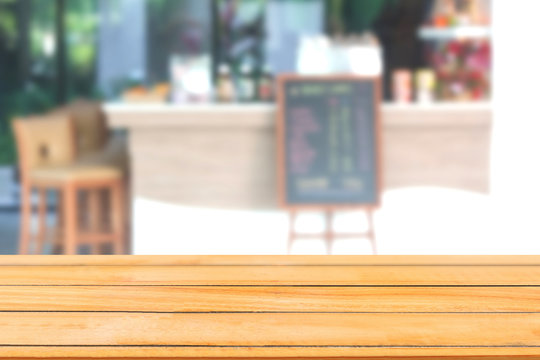 Abstract image of Empty wooden table with blurred coffee shop.