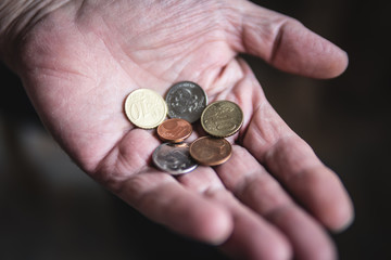 coins in the hands of an elderly man