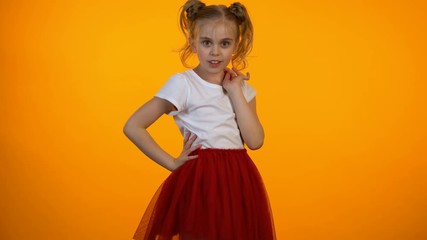 Cute little princess in red skirt flirting, girl pretending to be model, dream