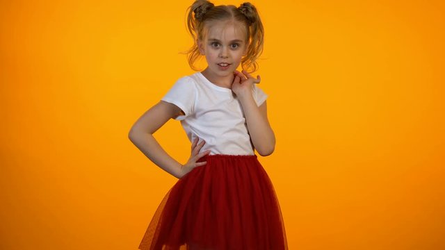 Cute little princess in red skirt flirting, girl pretending to be model, dream