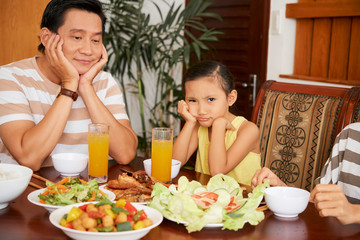 Bored dad and daughter at dinner table