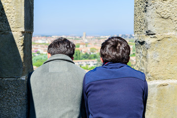 Par de Jóvenes en mirador observando un pueblo medieval