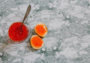 Top view of Sandwiches with red caviar on White marble background .Free space for text. Black caviar. Luxurious culinary delicacy. Close-up salmon caviar. Seafood. Red caviar close-up background. 