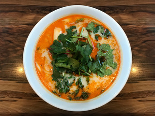 ShangHai hot sauce noodles in red soup bowl on wood table background.