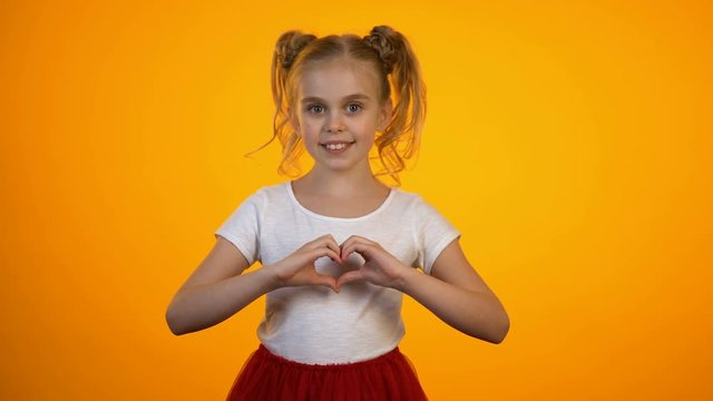 Adorable teen girl making heart with hands, love and care, cardiology and health