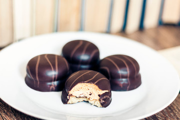 chocolate cookies on white plate with Stack of books on the background .