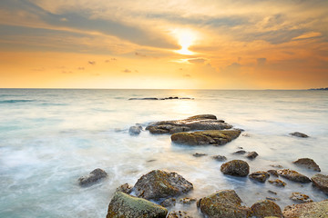 Fototapeta na wymiar Beautiful seascape with sunset on the rocky shore of a tropical beach and Island