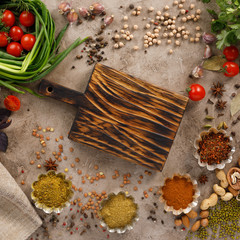 Fresh greens and tomatoes spices cereals and nuts organic healthy snacks on a textural background....