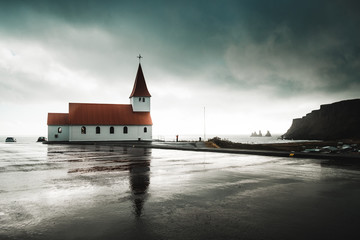 Church of Vik I Myrdal with reflection on wet ground, Iceland