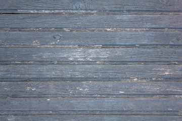 Obraz premium old wooden gray fence made of planks with peeling paint, cracks and white spots close up. horizontal lines. rough surface texture
