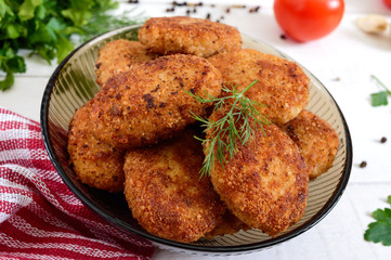 Juicy homemade cutlets (beef, pork, chicken) on a white wooden background.