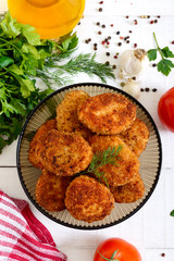 Juicy homemade cutlets (beef, pork, chicken) on a white wooden background.
