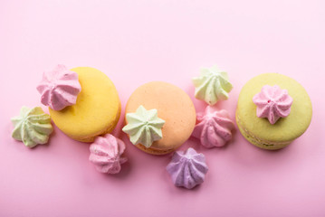 Dessert cake macaron or macaroon on pink background top view. Flat lay composition.