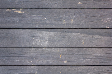 old wooden fence of painted boards with gray peeling paint with cracks and scratches close-up. horizontal lines. rough surface texture