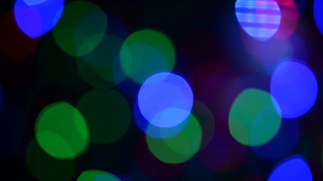 Abstract background of christmas lights. Smooth movement. Shaking from the wind. Flickering colored lights on a dark background. Defocused image. Colorful Christmas lights